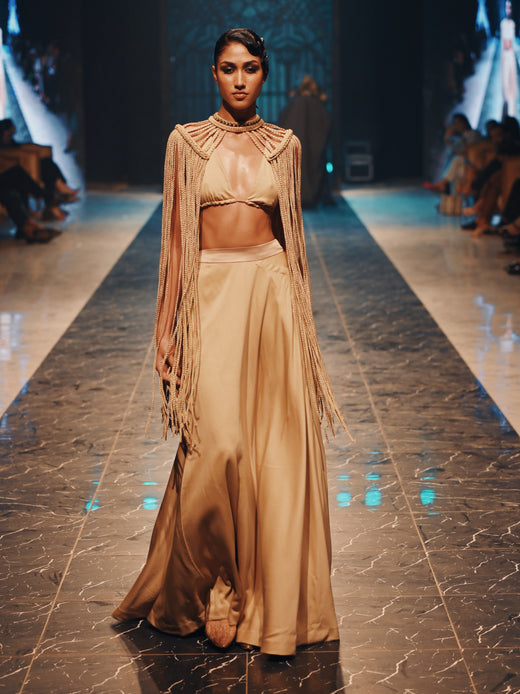 Braided poncho with gold bikini and gold skirt